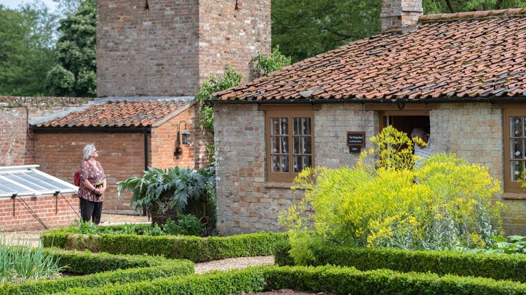 Two visitors explore the Kitchen Garden at Oxburgh Hall in Norfolk